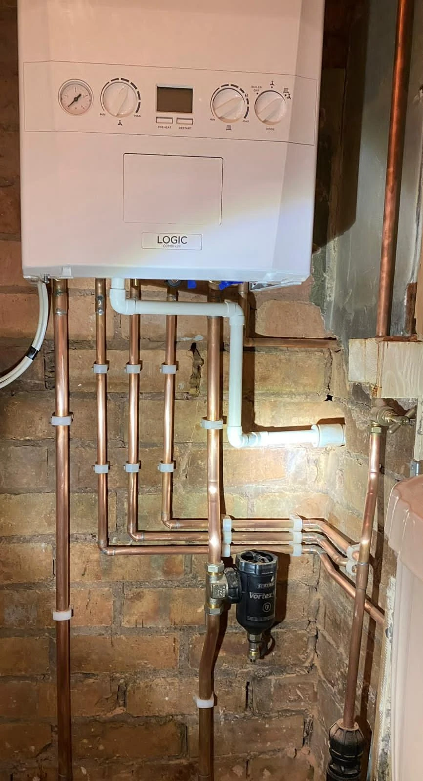White boiler with copper pipes.